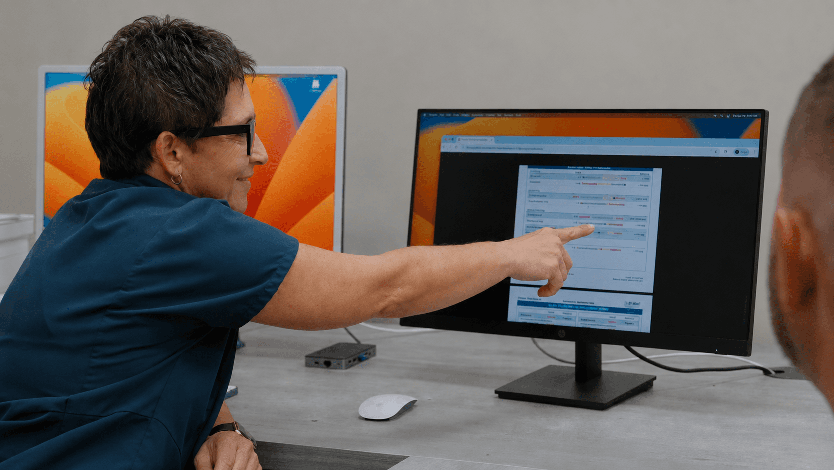 Med Matrix provider pointing at lab results on screen during a patient consultation