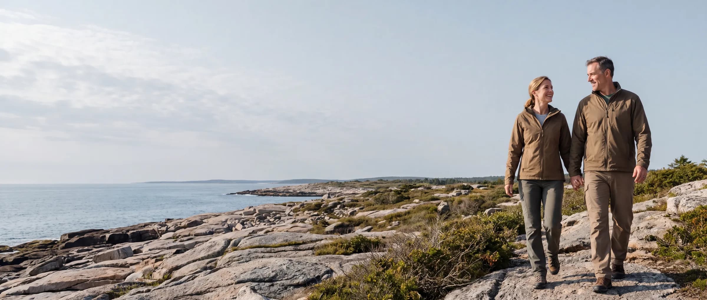 A couple walking together along a rocky coastal trail