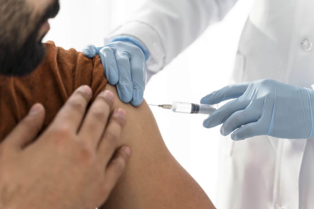 A healthcare professional wearing gloves administers a Priapus Shot (P-Shot) injection into a person's upper arm, a procedure sometimes associated with male enhancement treatments. in Portland Maine